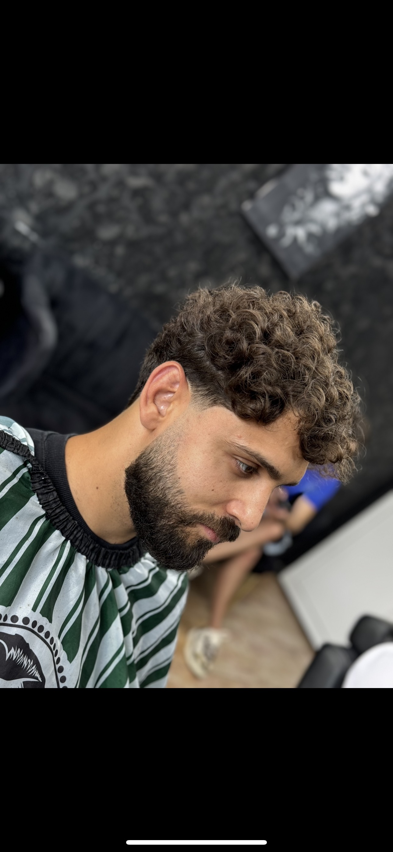 Client al frizeriei cu tunsoare de tip Taper fade si parul cret